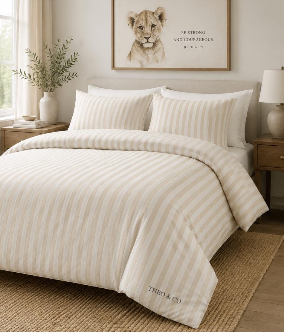 A neatly made bed in a softly styled bedroom, featuring a cream and beige striped duvet cover and matching pillow shams. The brand name 'THEO & CO.