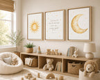 Three framed nursery wall art prints hang above a wooden storage shelf in a styled children's room. The prints feature a yellow sun, a scripture quote, and a gold crescent moon with small stars.