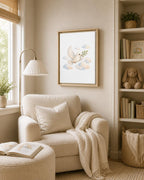 A framed art print featuring a white dove flying among soft clouds, hanging on a beige wall above a cream-colored armchair in a cozy, sunlit room.