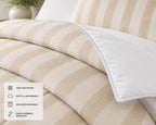 Beige and cream striped bedding set featuring a duvet cover and matching pillowcases, with a white pillow shown in the foreground. A white informational overlay in the bottom-left corner lists product features: 100% polyester, soft and lightweight, machine washable, and fade & wrinkle resistant.