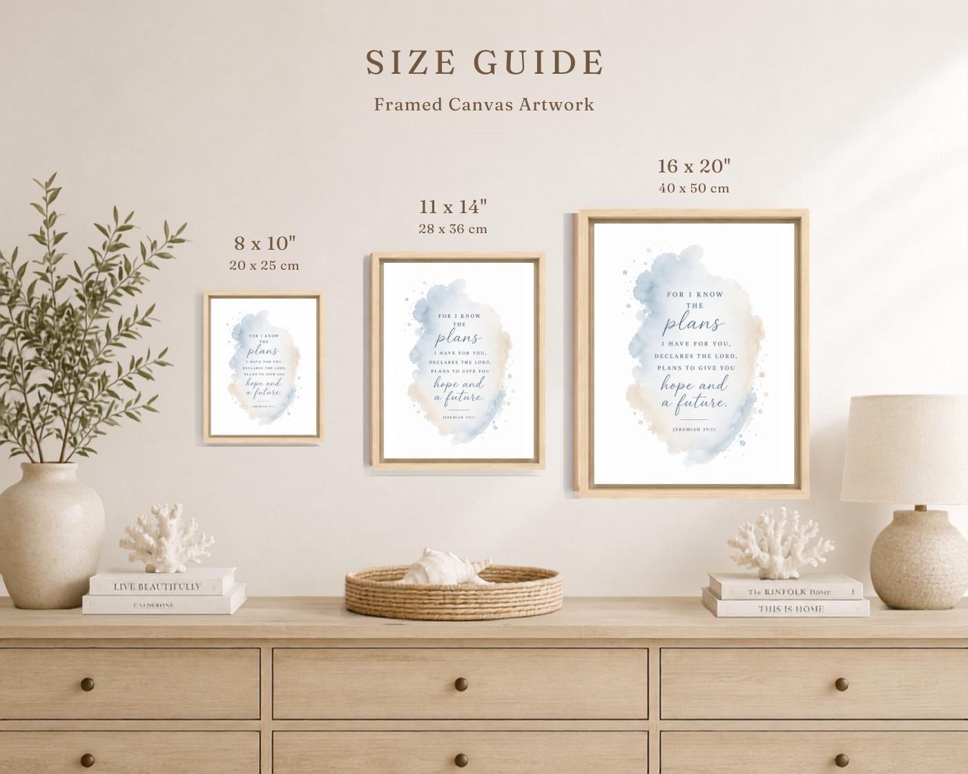 A size guide mockup showing three framed canvas art prints in different sizes (8 x 10, 11 x 14, and 16 x 20 inches) hanging on a beige wall above a light wood console table decorated with a vase of greenery, books, and a lamp.