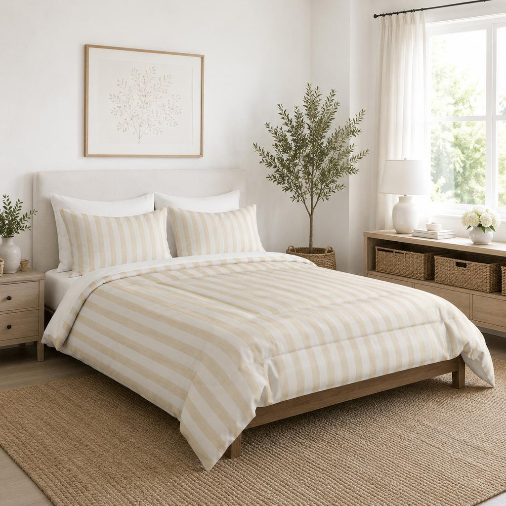 A neatly made bed in a bright, modern bedroom featuring a cream and beige striped duvet cover and matching pillow shams, set against a white wall with a wooden headboard.
