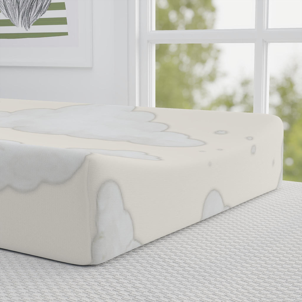 A fitted sheet with a soft gray cloud pattern on an off-white mattress, shown in a bright, modern bedroom setting next to a window.