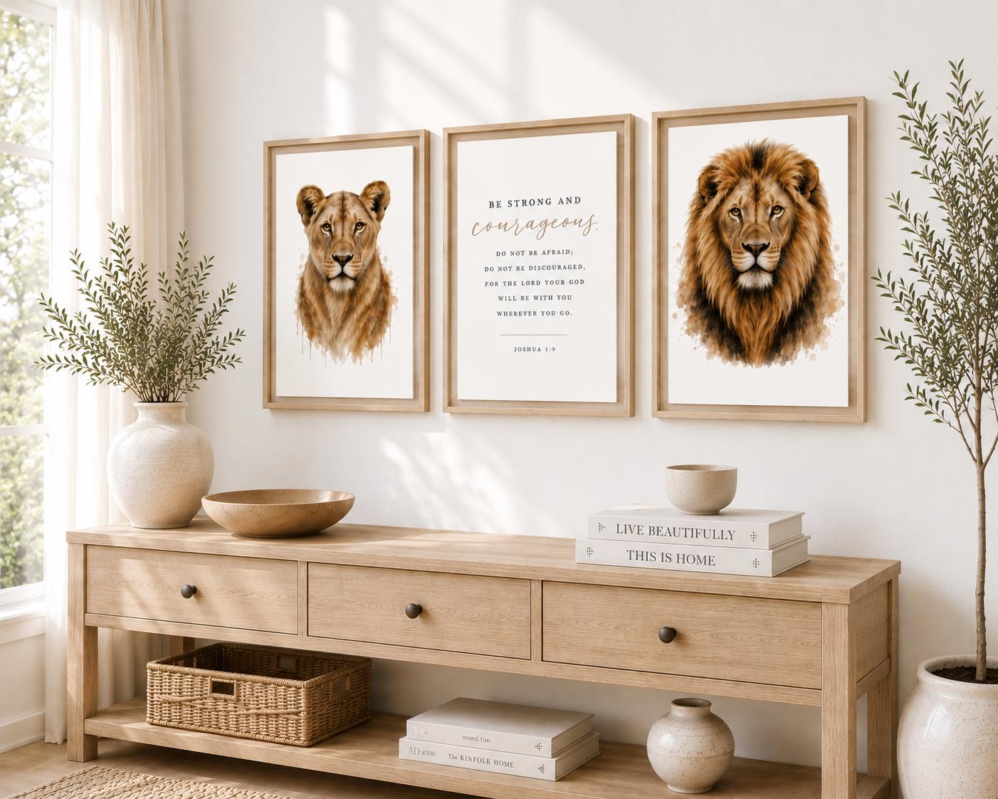 Three framed wall art prints hang above a light wood console table in a bright, styled room. The left print shows a lion cub, the center print features an inspirational quote, and the right print shows a lion.