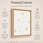 A framed canvas wall art product shown on a beige promotional background with text callouts. The artwork features a white canvas with scattered gold stars and a light natural wood floating frame.