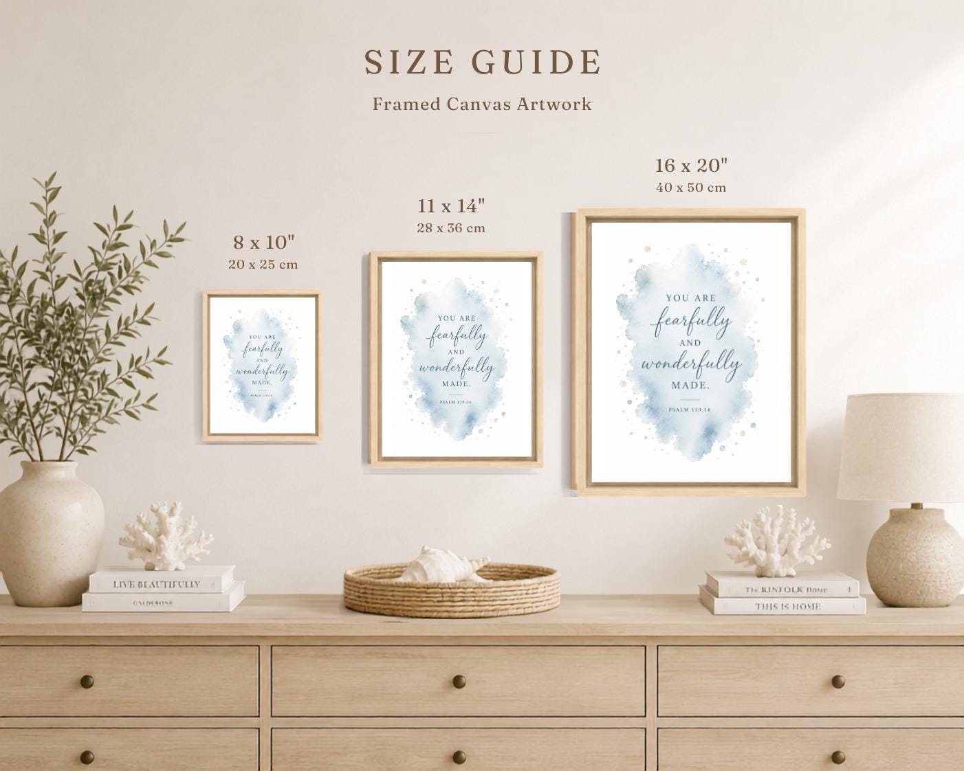 A size guide graphic showing three framed canvas art prints in different sizes mounted on a beige wall above a light wood console. The text reads 'SIZE GUIDE Framed Canvas Artwork' with dimensions for each print: 8 x 10 inches, 11 x 14 inches, and 16 x 20 inches.