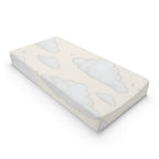 A rectangular baby mattress protector or fitted sheet with a soft cloud pattern in light gray on a warm cream background, shown at an angle on a white background.