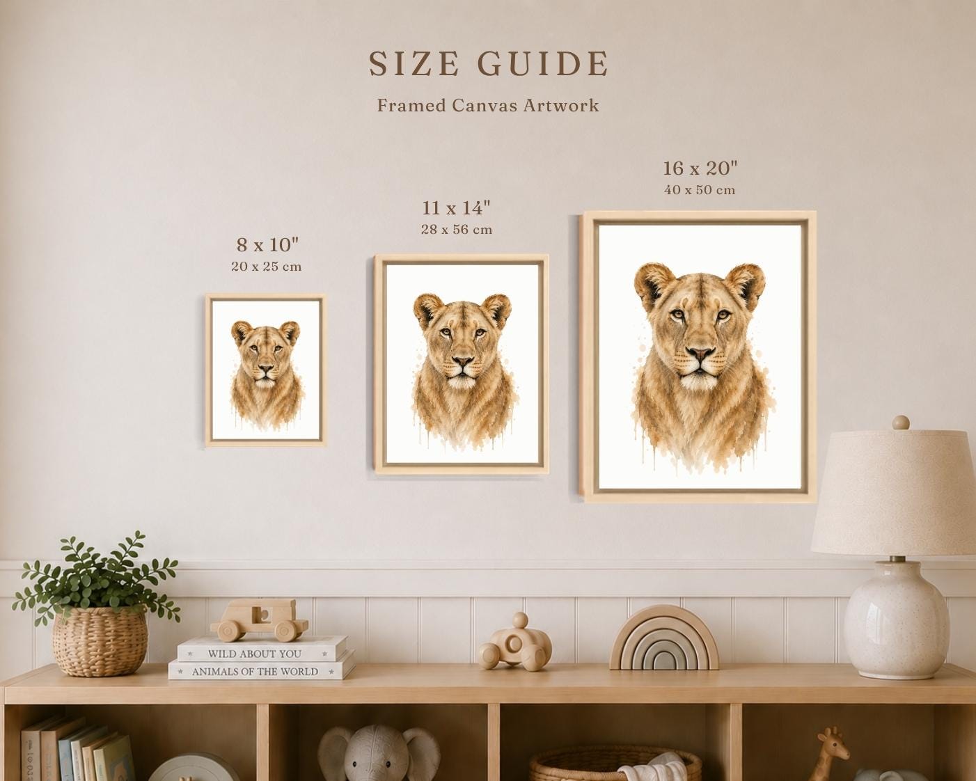 A size guide poster showing three framed canvas prints of lion cub portraits in different dimensions (8 x 10, 11 x 14, and 16 x 20 inches) mounted on a beige wall above a wooden shelf with home decor.