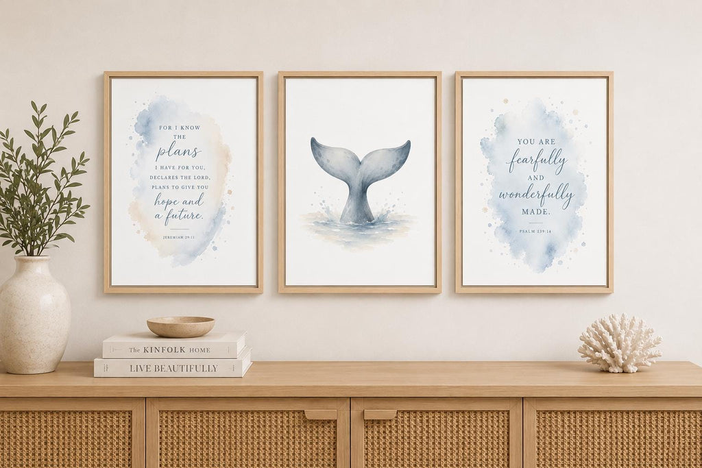 Three framed watercolor art prints with nautical and inspirational designs, displayed on a beige wall above a wooden console table with decorative props.