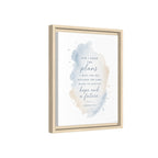 Framed wall art featuring a Bible verse in elegant black and blue script over a soft watercolor splash in blue, beige, and gray tones, shown in a light natural wood frame against a white background.