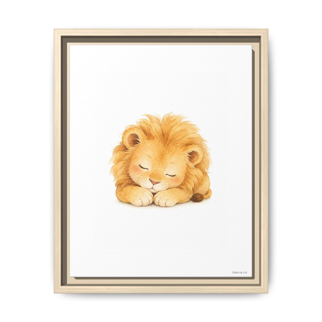 A framed art print featuring a cute watercolor illustration of a sleeping golden lion. The print is housed in a light natural wood frame with a dark inner border, set against a clean white background.