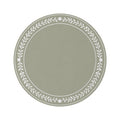 A round area rug in sage green with a white leafy floral border, styled on a white background