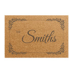 A rectangular natural coir doormat with a dark brown printed border, the words "THE Smiths" in script, and a personalized name design on a white background.