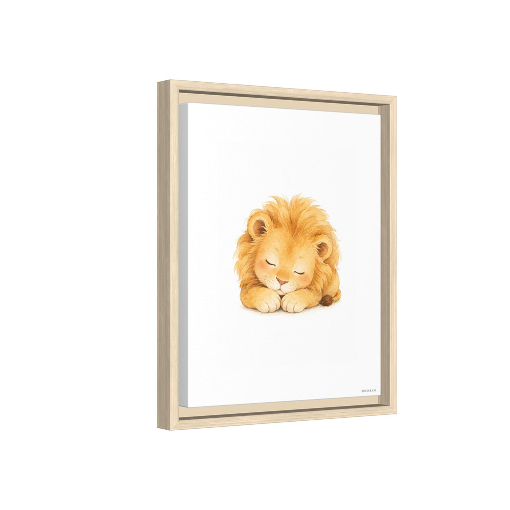 A framed art print featuring a watercolor illustration of a sleeping golden lion on a white background, housed in a light natural wood frame.