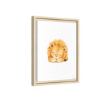 A framed art print featuring a watercolor illustration of a sleeping golden lion on a white background, housed in a light natural wood frame.