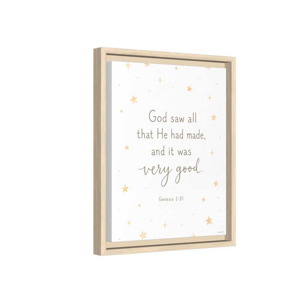 A framed wall art print with a light wood frame, featuring the quote 'God saw all that He had made, and it was very good. Genesis 1:31' in gray text on a white background with scattered small gold stars.