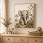 A framed art print of a baby elephant hanging on a beige wall above a wooden dresser in a safari styled nursery. The print features a detailed sepia-toned illustration of a baby elephant on a rock, flanked by leaves.