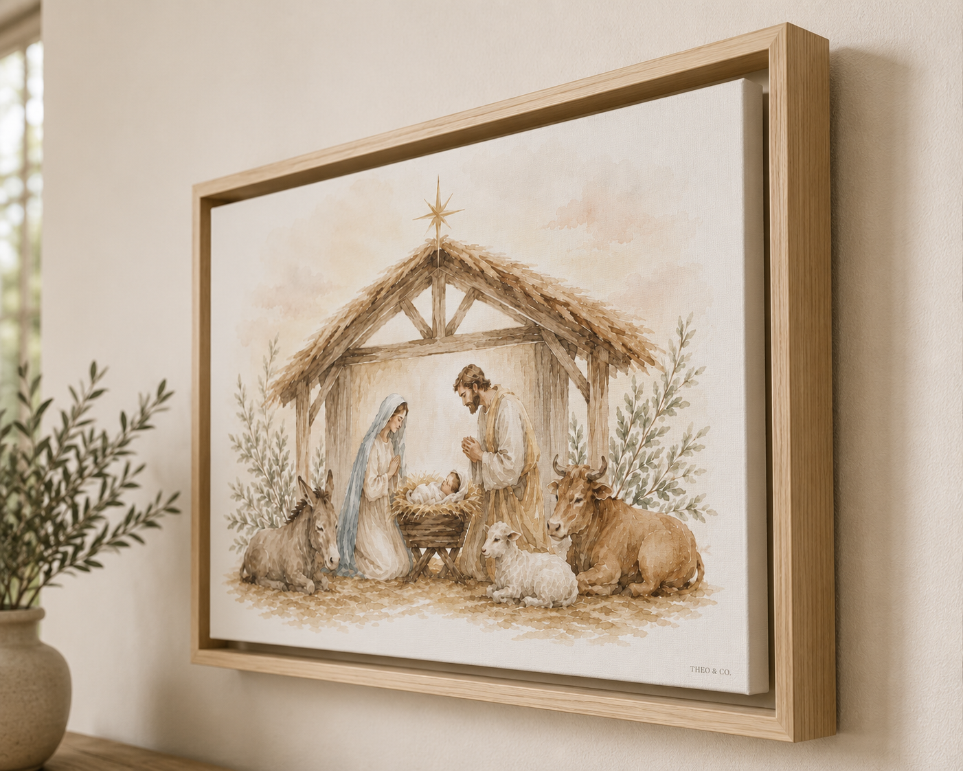 A framed art print depicting a serene nativity scene with Mary, Joseph, baby Jesus in a manger, and animals, hung on a light beige wall next to a potted plant.