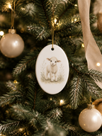An oval Christmas ornament featuring a painted white lamb standing in a field, hanging on a decorated Christmas tree with warm lights and gold baubles.