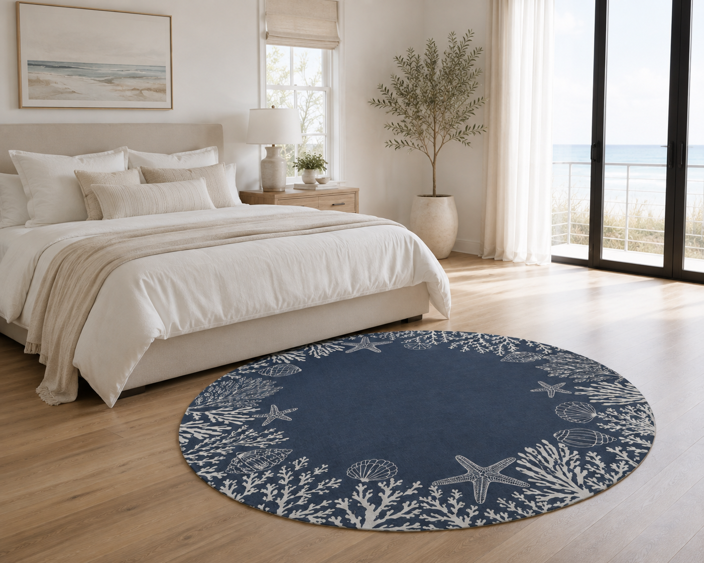 A round navy blue area rug with a white starfish and coral pattern, styled in a bright, modern bedroom next to a bed with neutral bedding.