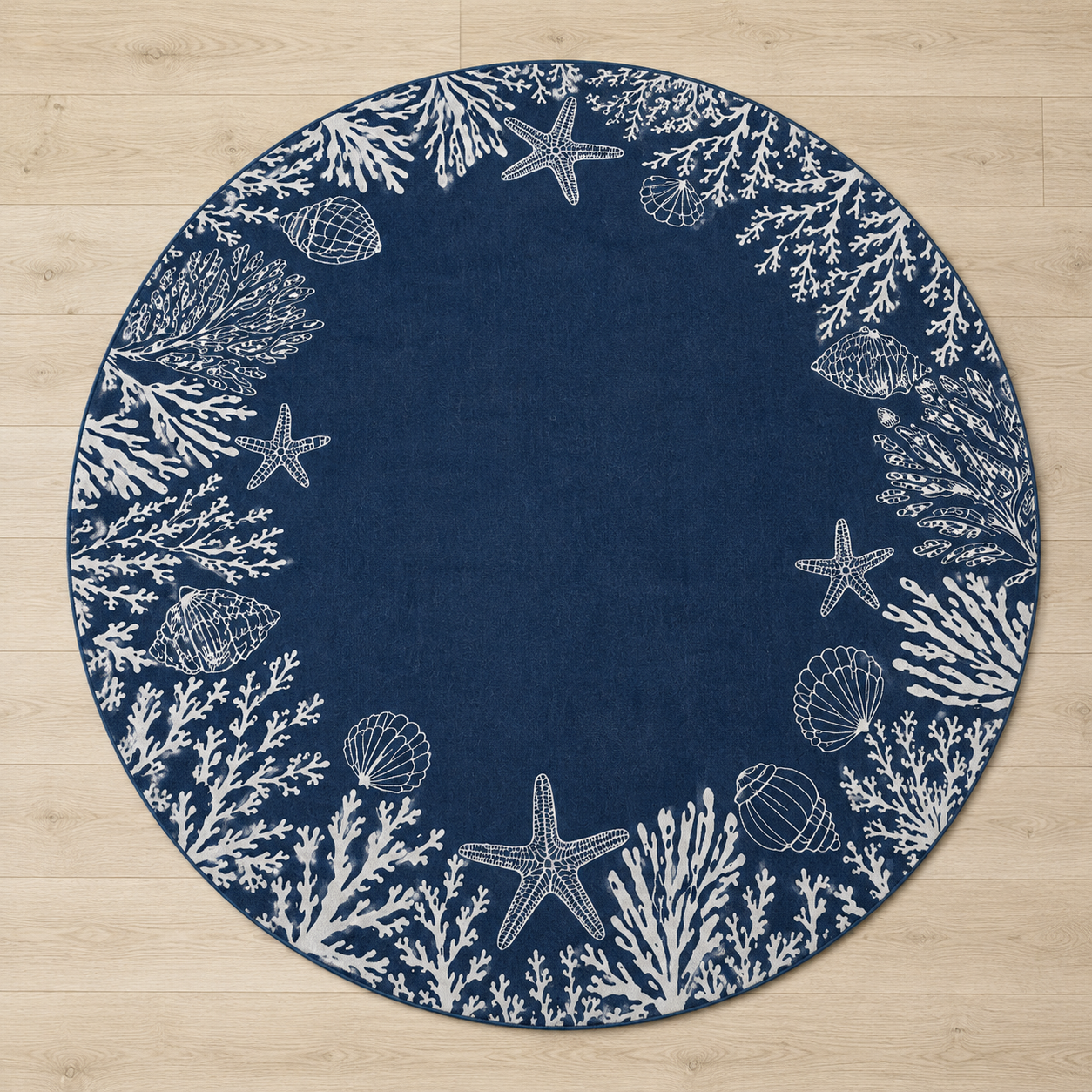 A round navy blue rug with a white seashore pattern featuring starfish, shells, and coral, laid flat on a light wood floor.