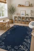 A navy blue area rug with a white nautical print of starfish, seashells, and coral, styled in a bright children's room next to a wooden table, storage shelves, and a white chair.