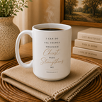 A white ceramic coffee mug with a Bible verse printed on it, sitting on a woven placemat with a folded napkin, coffee inside, and decorative books and a plant in the background.