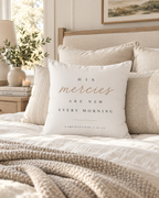 Lamentations 3:22-23 scripture pillow cover on a neutral sofa