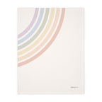 A cream-colored fabric item, likely a blanket or towel, featuring a minimalist pastel rainbow design in the upper-left corner and the text 'THIO & CO.' in the lower-right corner.