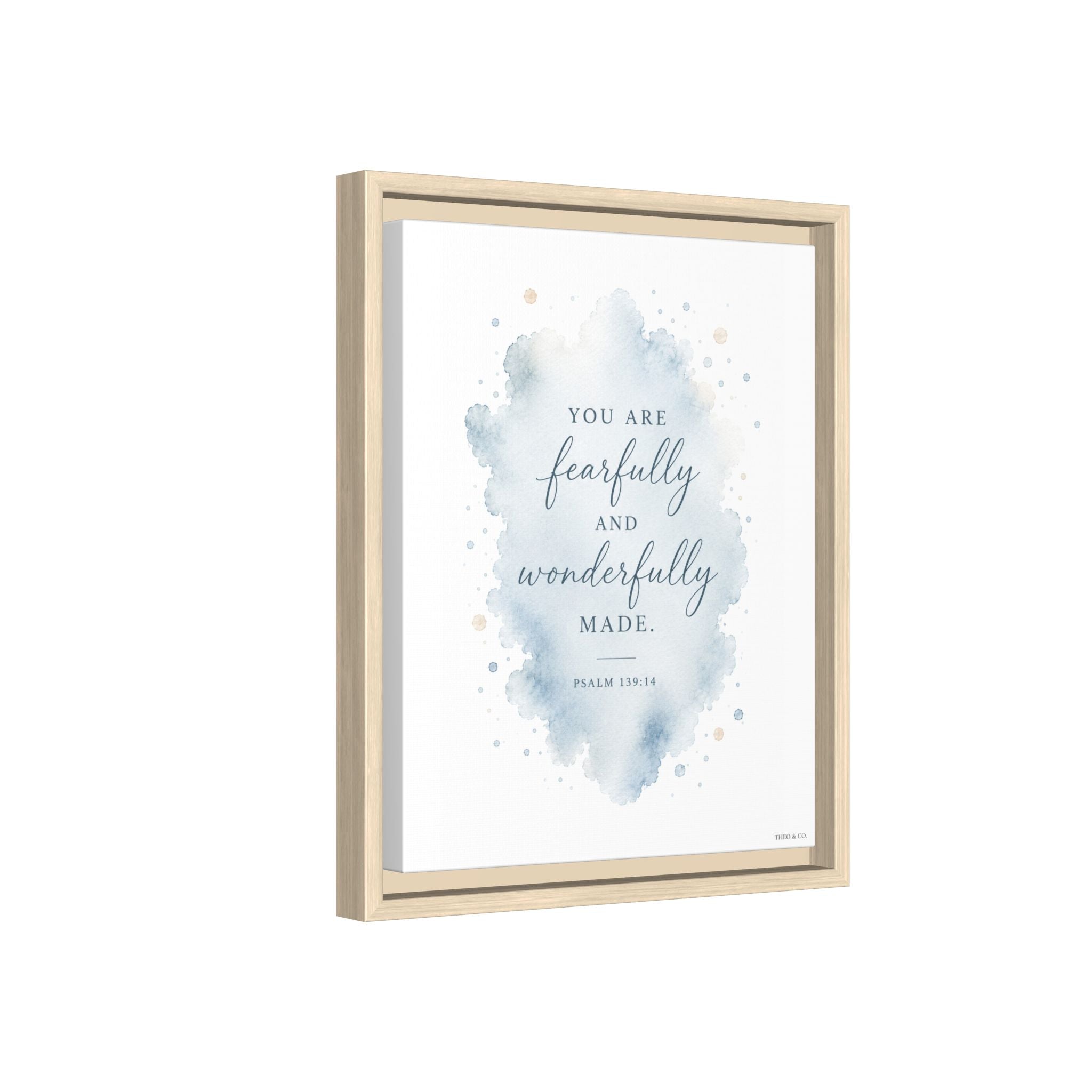 Framed wall art print with a watercolor blue splash and the quote 'YOU ARE fearfully and wonderfully MADE.' on a white background, shown in a light natural wood frame against a white backdrop.