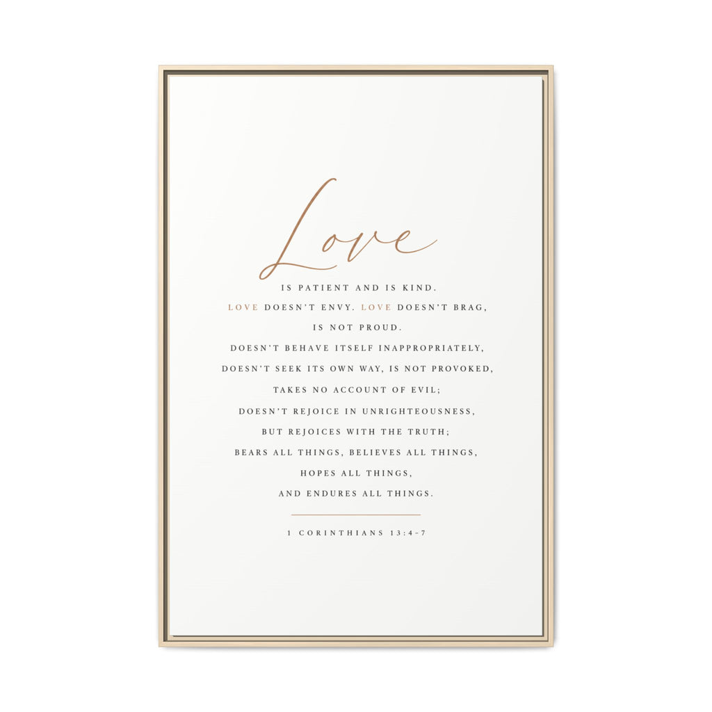 A framed typographic wall art print featuring the word 'Love' in large cursive at the top and a centered Bible verse from 1 Corinthians 13:4-7 in small serif text below, shown in a thin light wood frame against a white background.