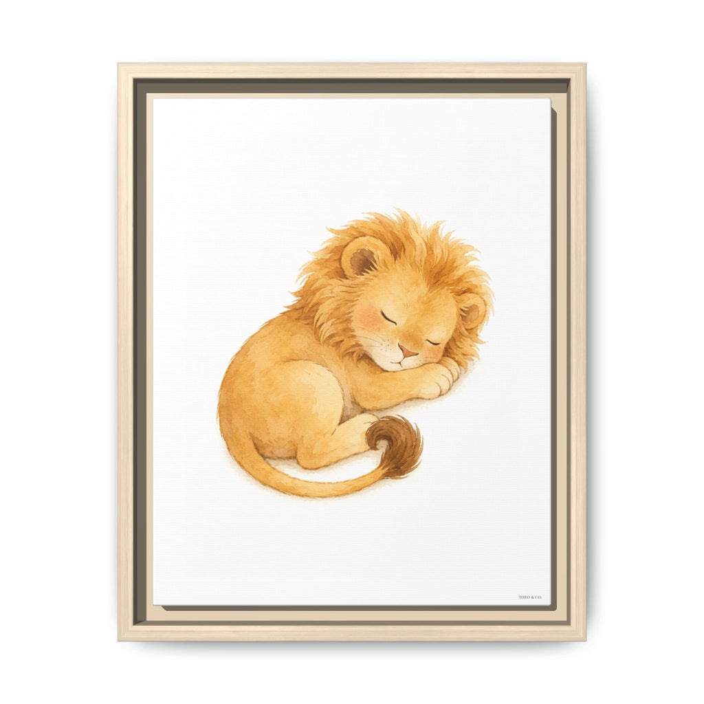 Framed wall art featuring a watercolor illustration of a sleeping lion cub in warm golden and tan tones on a white background, shown in a light wood frame against a white wall.
