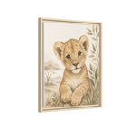 Framed wall art featuring a painted lion cub in a safari scene, shown at a slight angle against a plain white background.