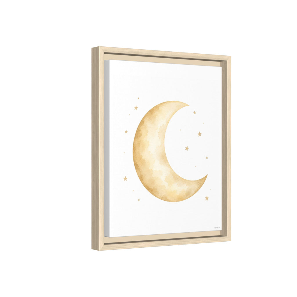 Framed wall art featuring a watercolor-style gold crescent moon and small stars on a white background, shown in a light natural wood frame against a white backdrop.