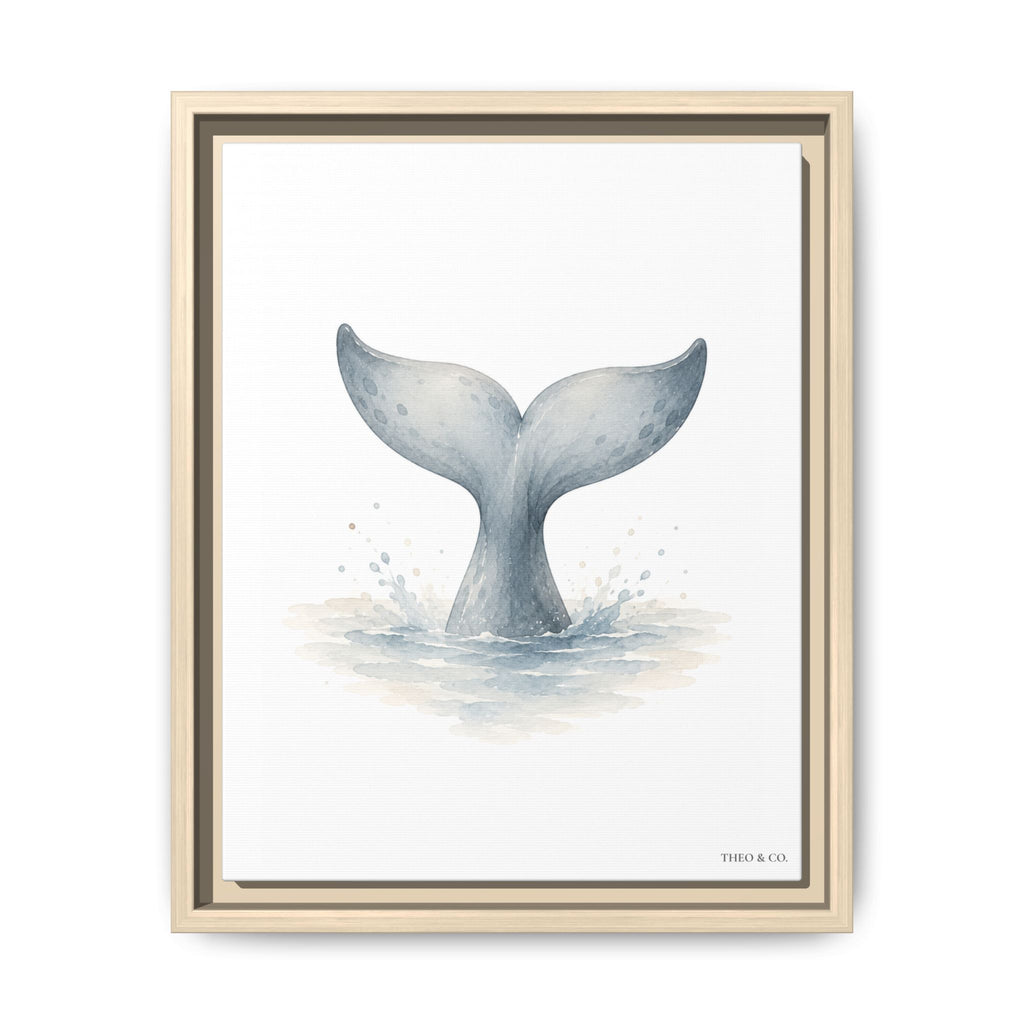 A framed art print featuring a watercolor illustration of a whale tail fin rising from the ocean, presented in a light natural wood frame against a clean white background.