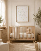 A styled nursery scene featuring a light wood crib with a cream blanket and stuffed bunny, beneath a framed wall print that reads 'You are loved beyond measure' with small gold stars. The room has warm neutral tones, a dresser, plants, and woven baskets.